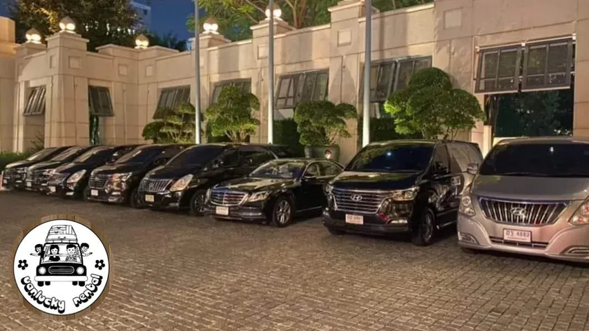 รถตู้และรถเก๋งจอดเรียงหน้าโรงแรมยามค่ำ